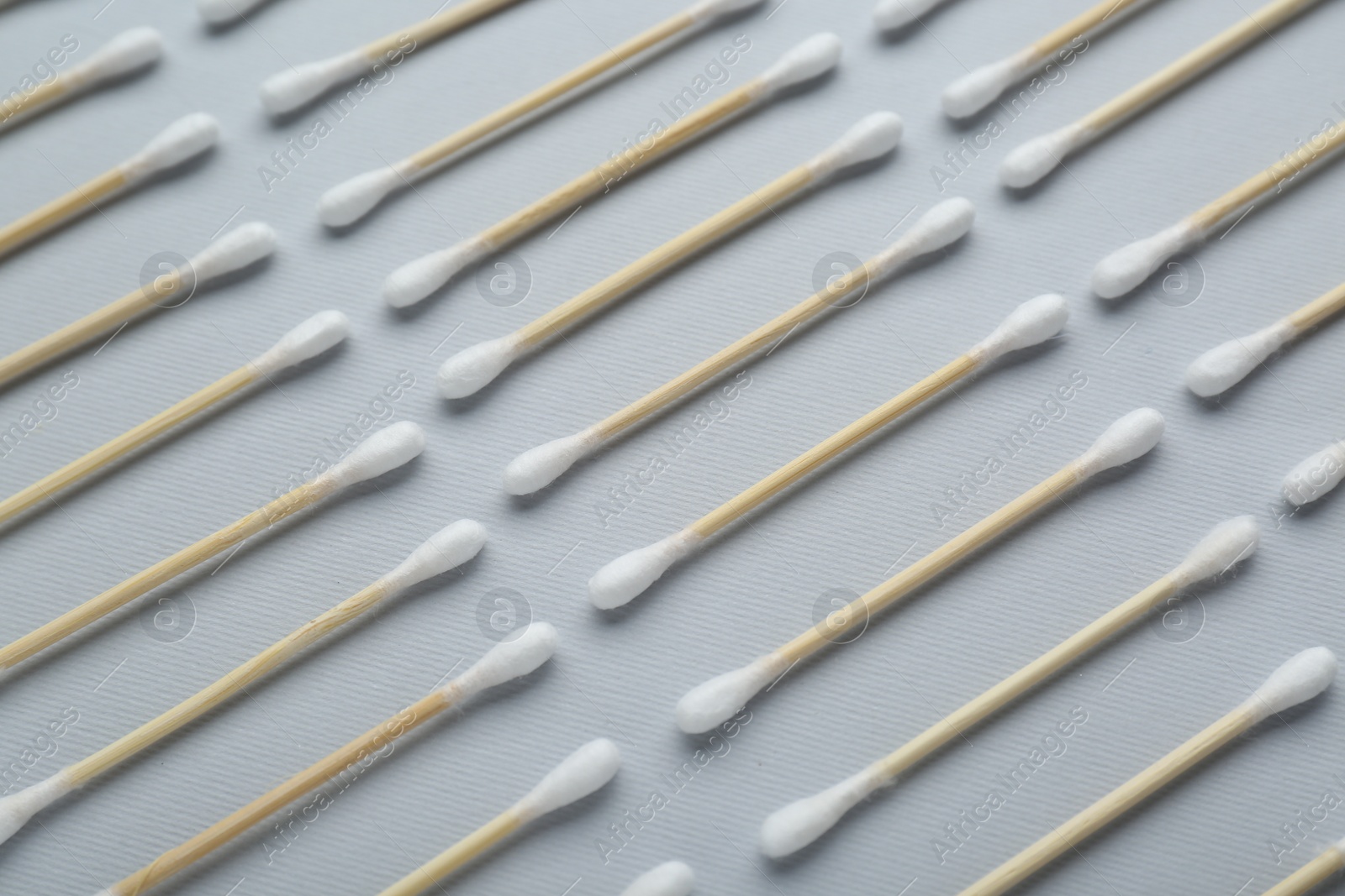 Photo of Many wooden cotton buds on light grey background, flat lay