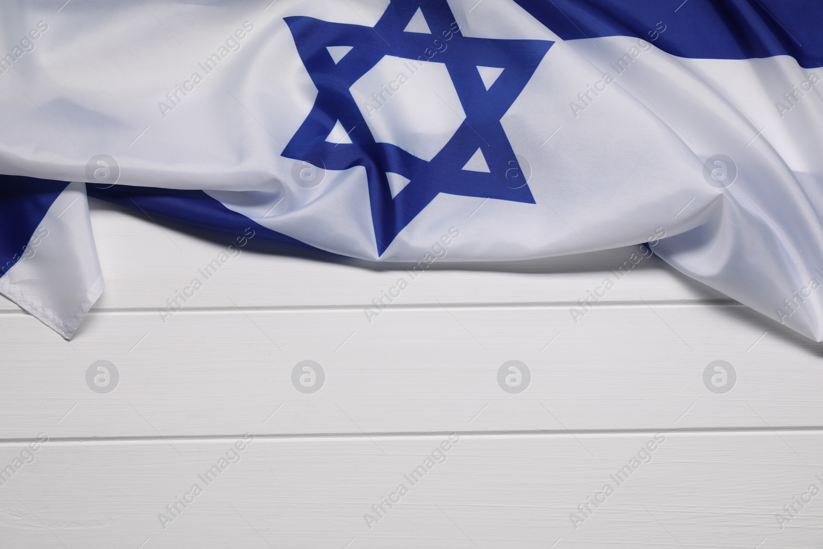 Photo of Flag of Israel on white wooden background, top view and space for text. National symbol