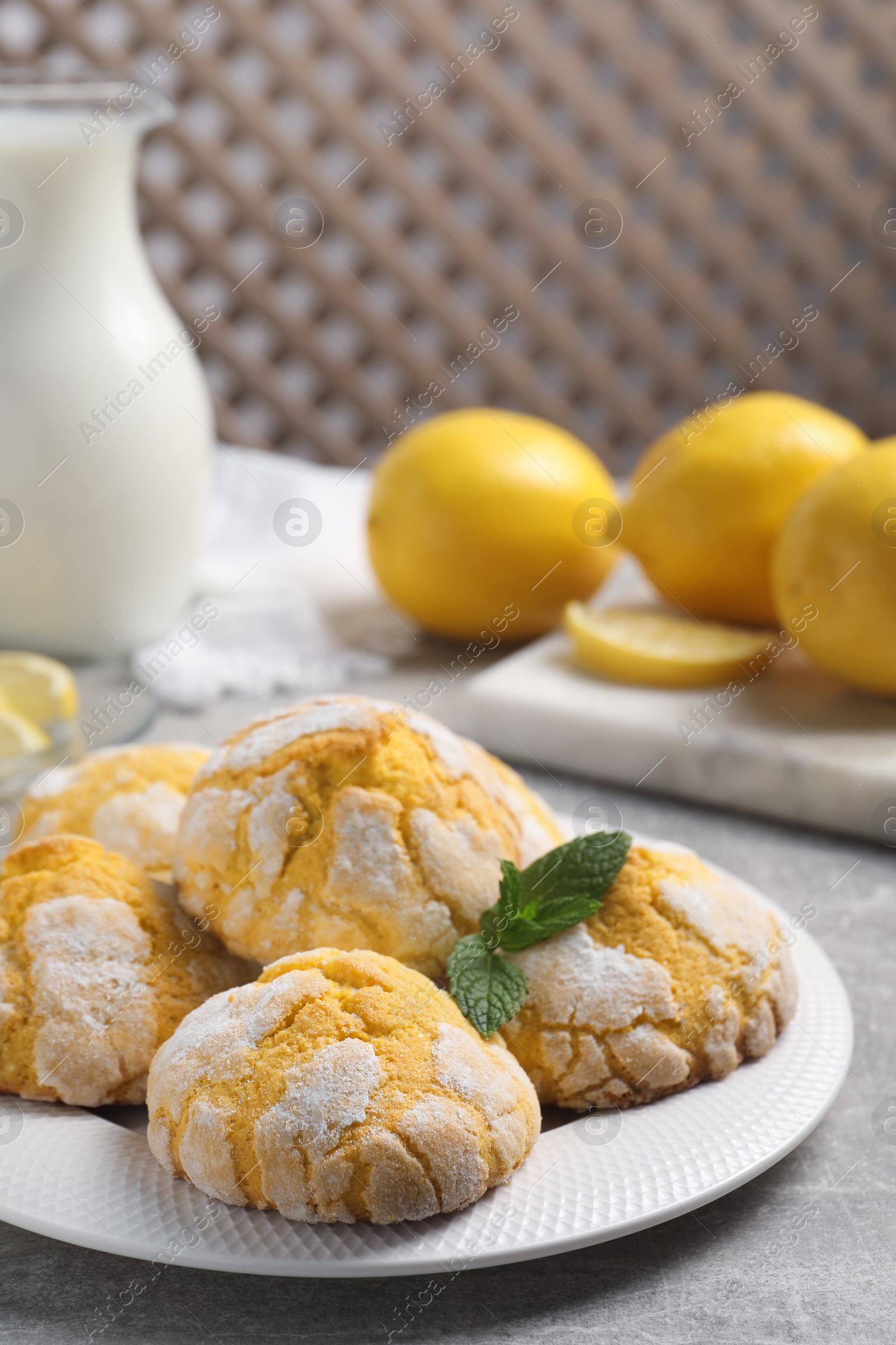 Photo of Plate with delicious lemon cookies and mint on grey table