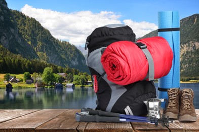 Image of Camping equipment for tourist on wooden surface and beautiful view of mountain landscape