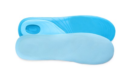 Photo of Light blue orthopedic insoles isolated on white, top view