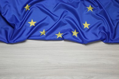 Photo of Flag of European Union on wooden table, top view. Space for text
