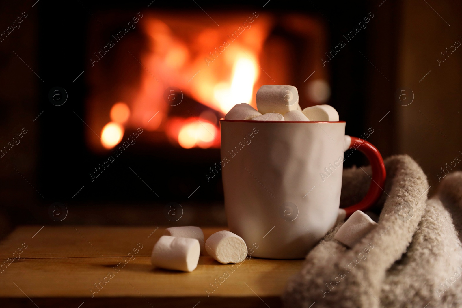 Photo of Tasty drink with marshmallows in cup on wooden table, closeup. Space for text