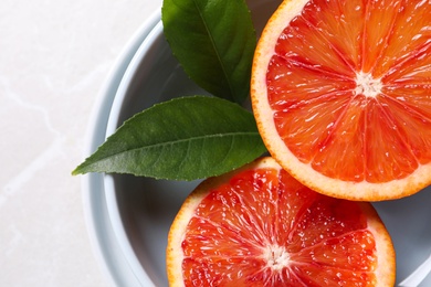 Photo of Slices of fresh ripe red orange on light  table, closeup