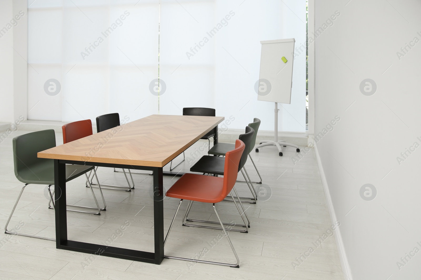 Photo of Conference room interior with wooden table and flipchart