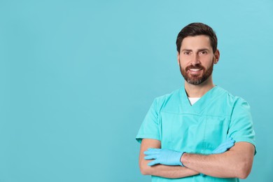 Photo of Happy nurse in medical uniform on light blue background, space for text