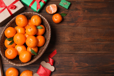 Flat lay composition with tangerines on wooden background. Space for text