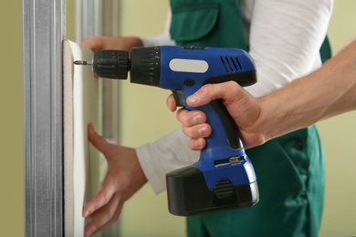 Photo of Workers installing drywall indoors, closeup. Home repair service