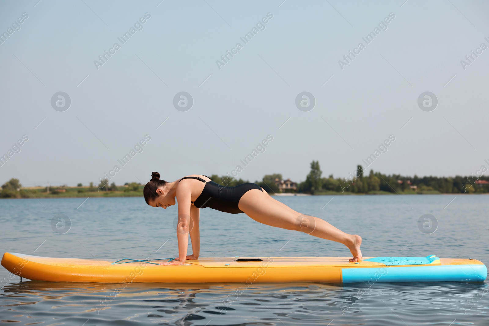 Photo of Woman practicing yoga on SUP board on river