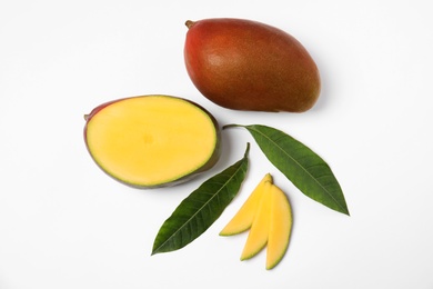 Photo of Tropical cut and whole mango with green leaves isolated on white, flat lay