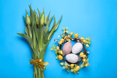 Flat lay composition with flowers and eggs on light blue background. Easter celebration