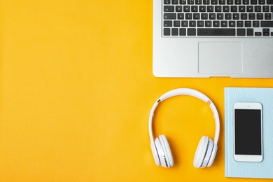 Photo of Flat lay composition with headphones, smartphone, laptop and space for text on color background