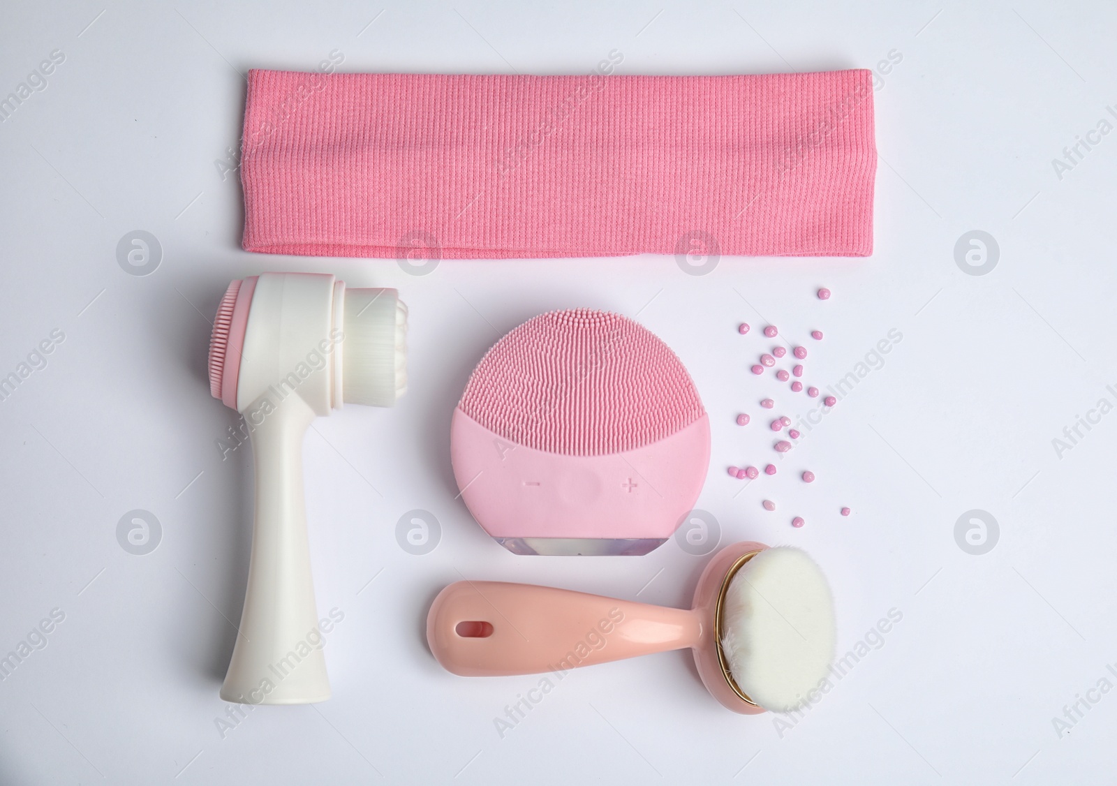Photo of Composition with face cleansing brushes on white background, top view. Cosmetics tools