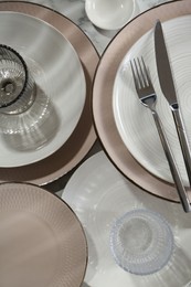 Stylish ceramic plates, cutlery and glasses on white marble table, flat lay