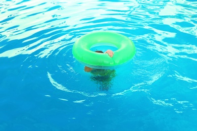 Little child with inflatable ring in outdoor swimming pool. Dangerous situation