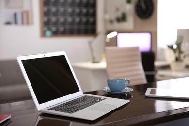 Photo of Stylish workplace with laptop on table