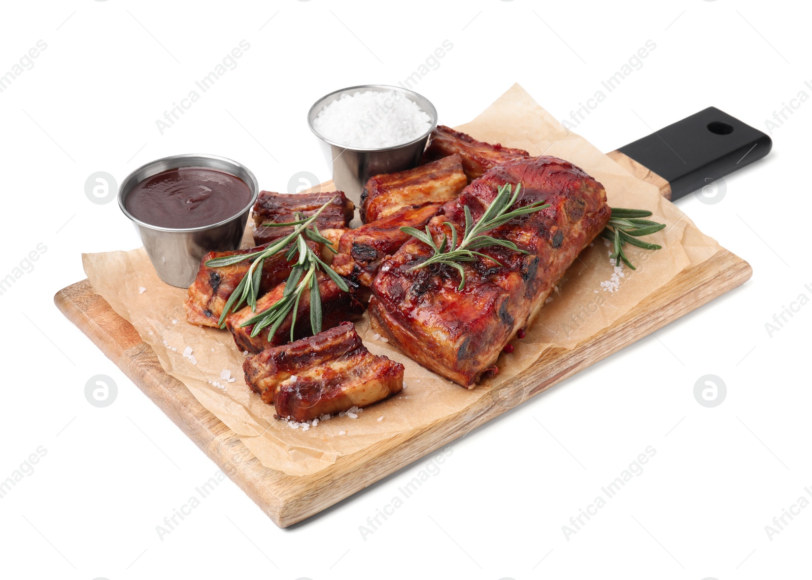 Photo of Tasty roasted pork ribs, rosemary and sauce isolated on white