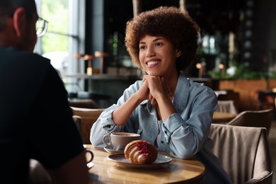 Photo of International dating. Lovely couple spending time together in cafe