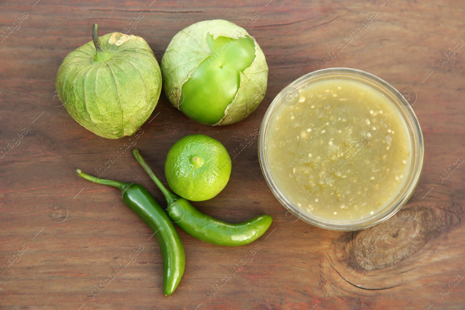 Photo of Tasty salsa sauce and ingredients on wooden table, flat lay