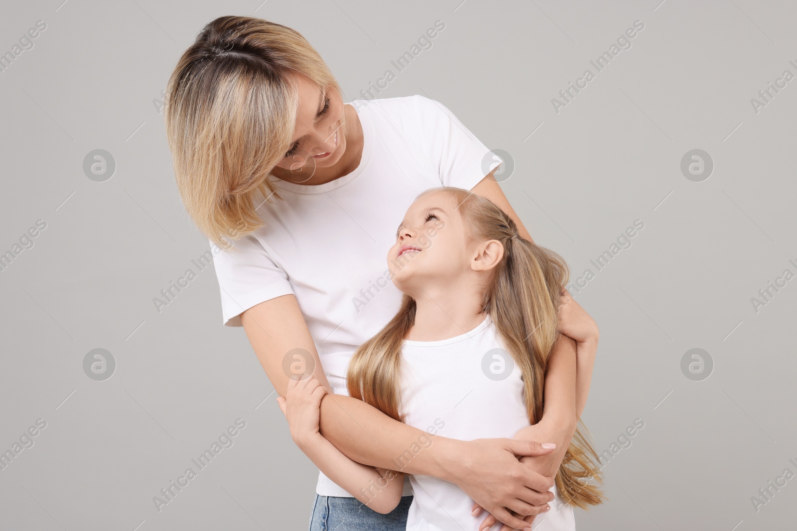 Photo of Family portrait of happy mother and daughter on grey background