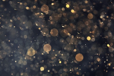 Photo of Golden glitter with bokeh effect on dark background