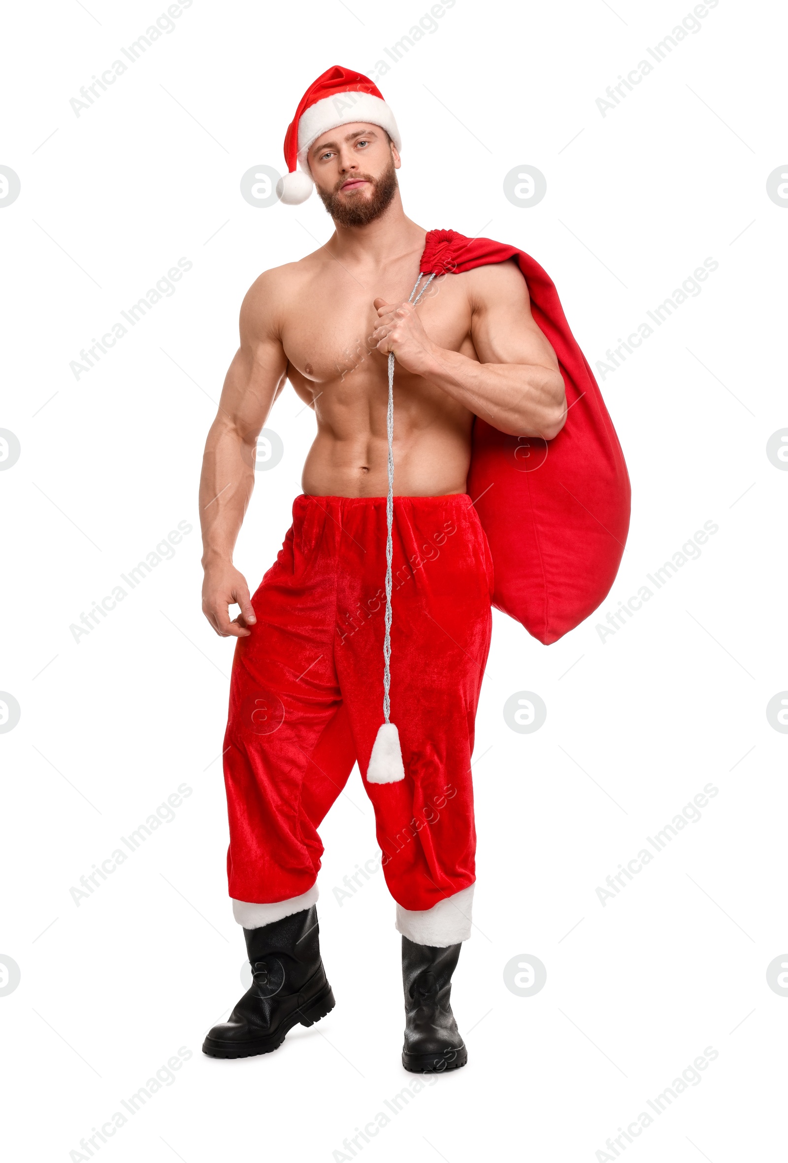 Photo of Muscular young man in Santa hat holding bag with presents on white background