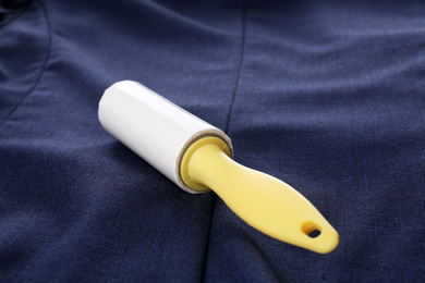 Photo of New lint roller with yellow handle on blue jacket