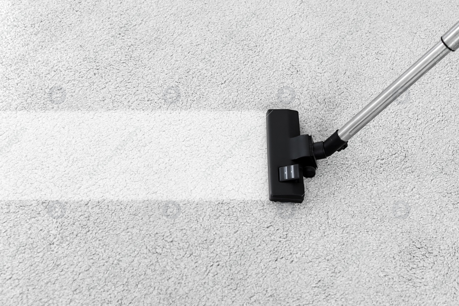 Photo of Removing dirt from soft carpet with vacuum cleaner indoors