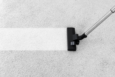 Removing dirt from soft carpet with vacuum cleaner indoors