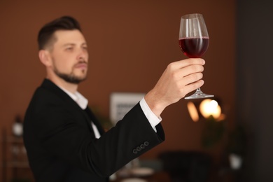 Photo of Young man with glass of wine indoors