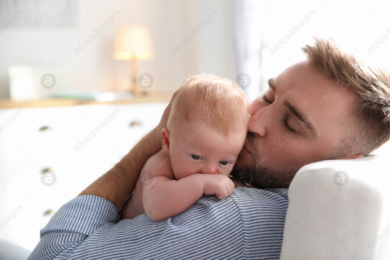 Photo of Father with his newborn son at home