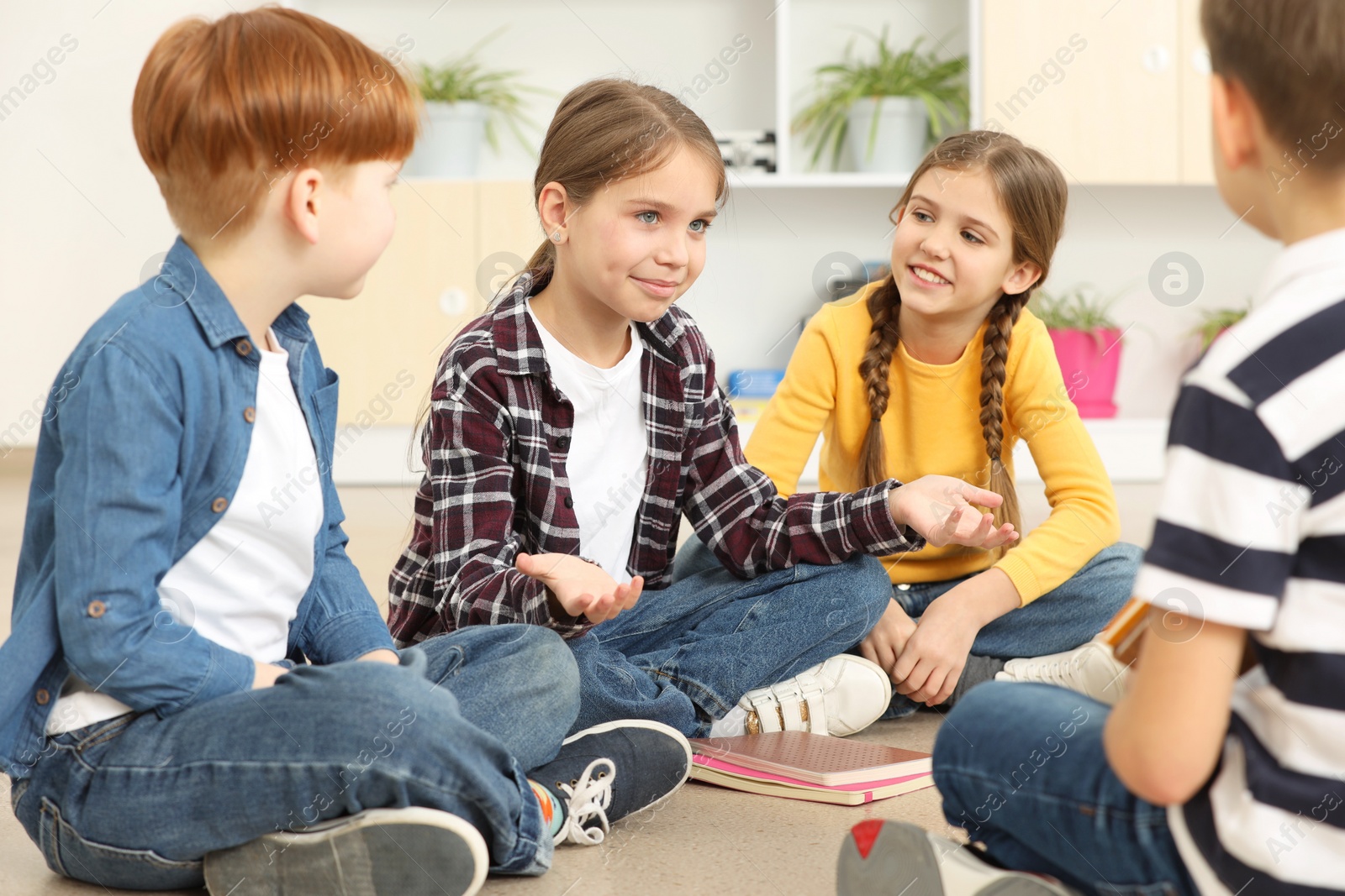 Photo of Cute children discussing in classroom at school