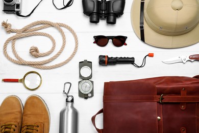 Photo of Flat lay composition with different safari accessories on white wooden background