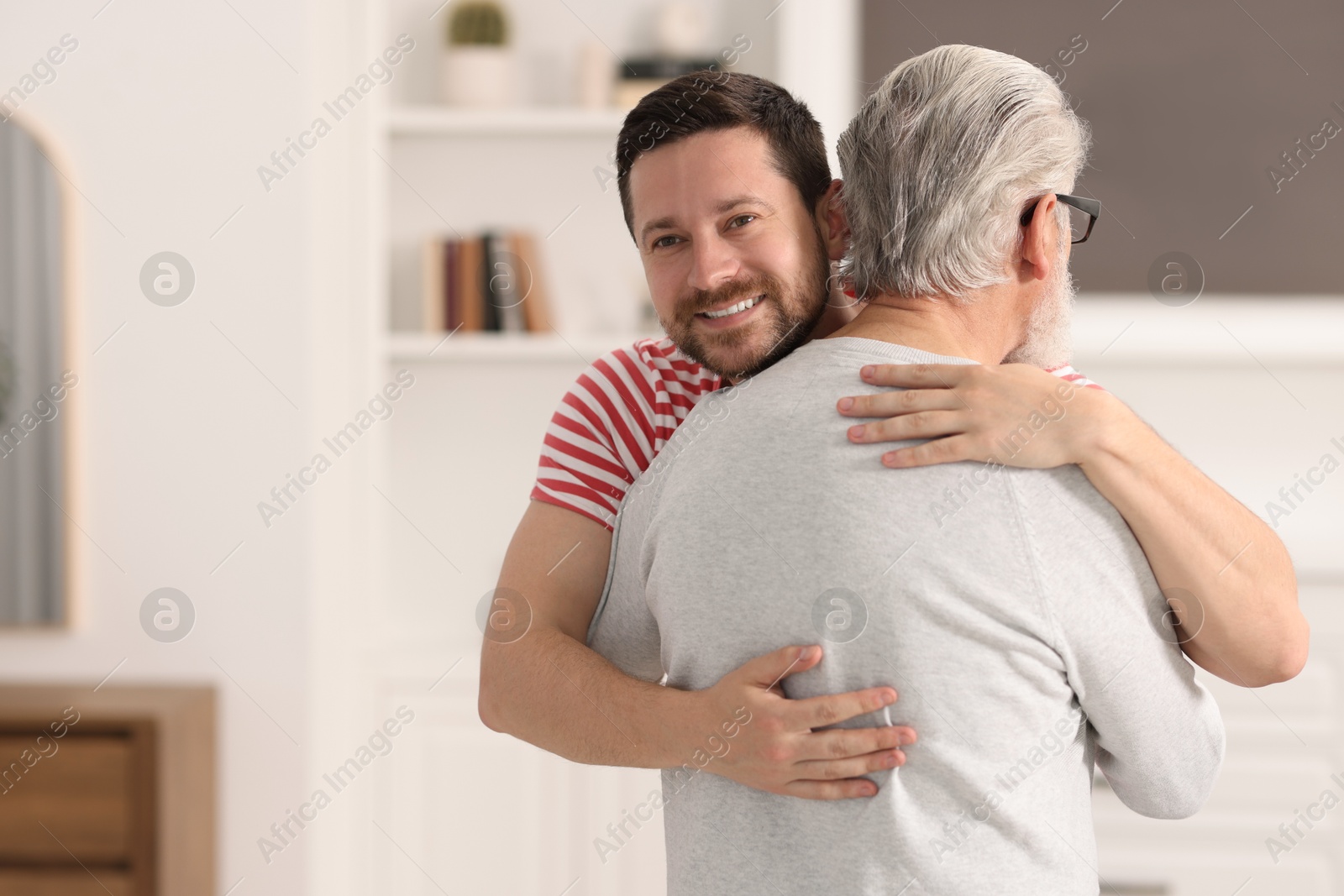 Photo of Happy son and his dad at home, space for text