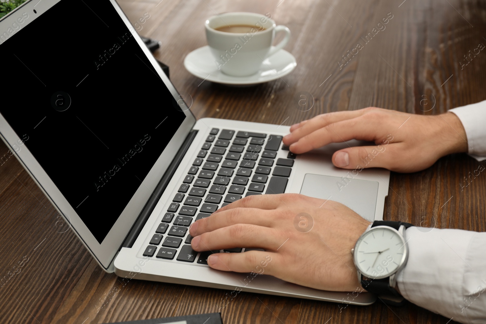 Photo of Man working with laptop at table, closeup. Space for design