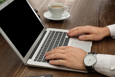 Man working with laptop at table, closeup. Space for design