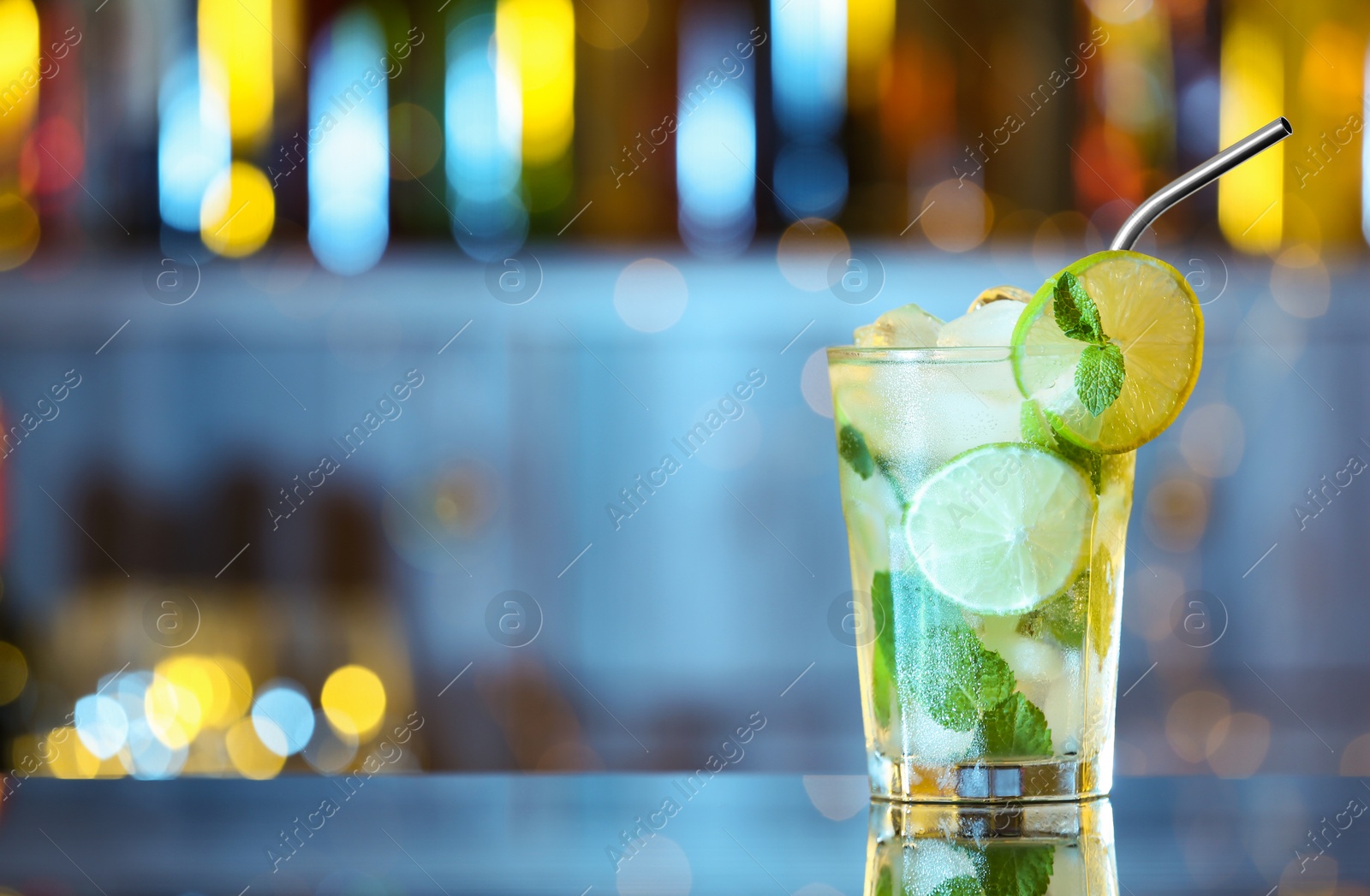 Photo of Glass of fresh alcoholic cocktail on bar counter. Space for text