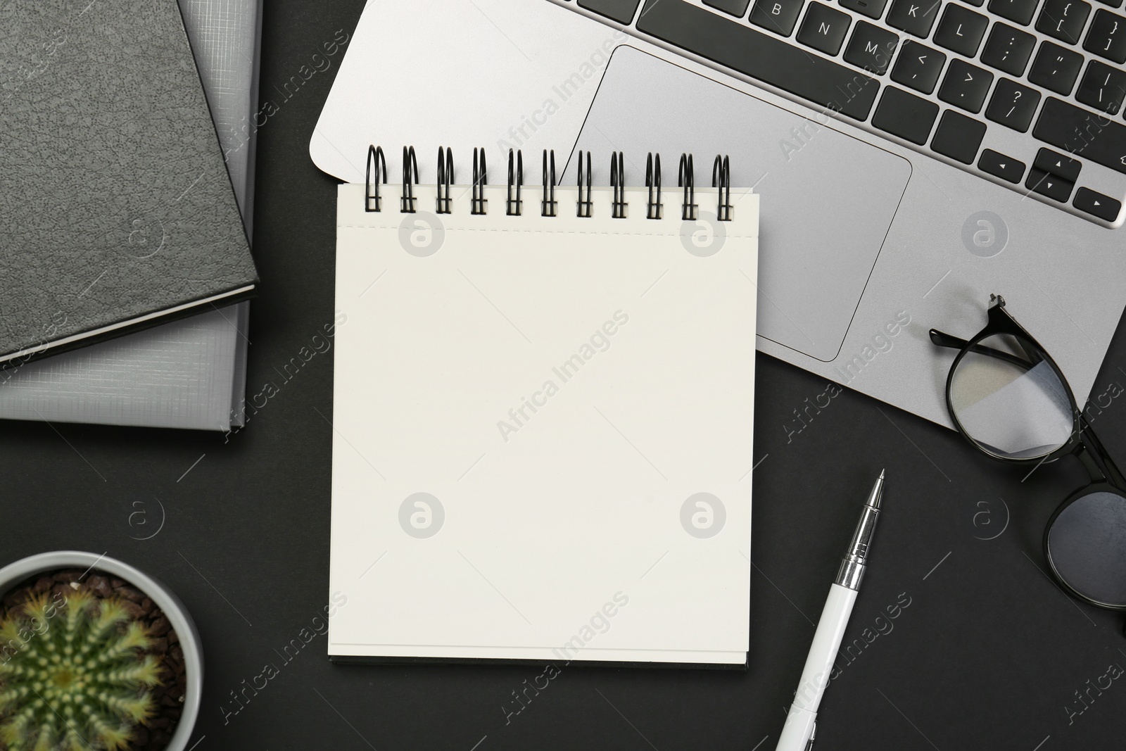 Photo of Flat lay composition with notebooks and laptop on black table