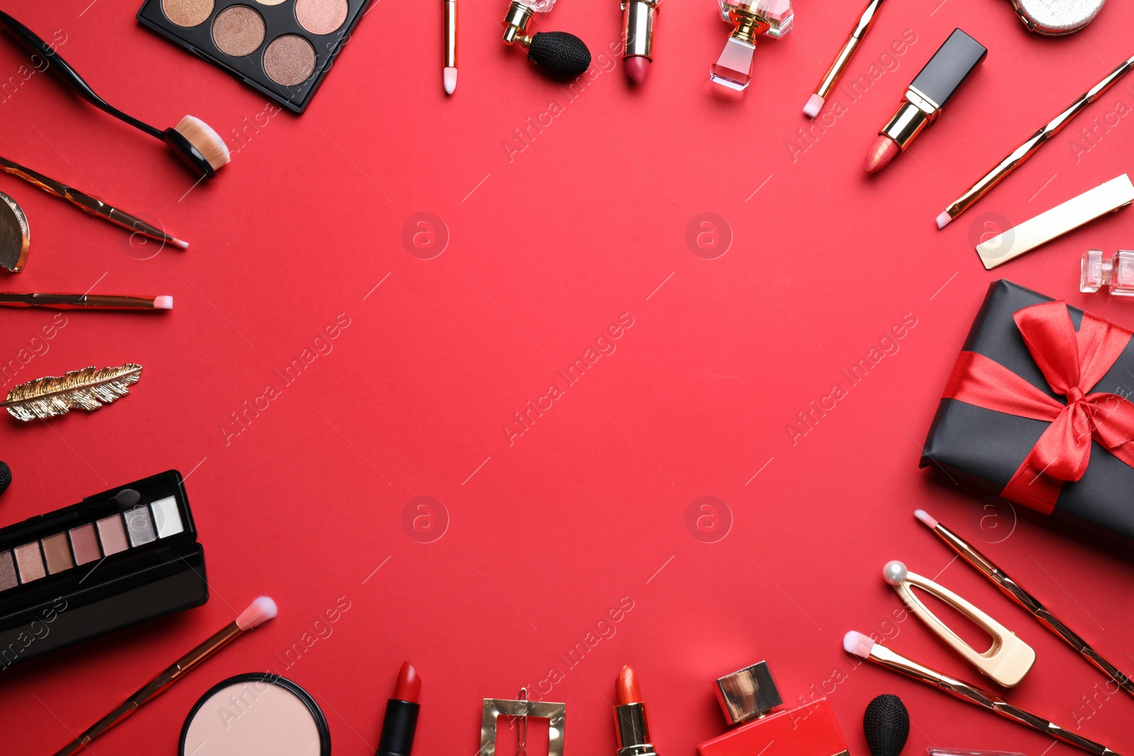 Photo of Makeup brushes and cosmetic products on red background, flat lay. Space for text