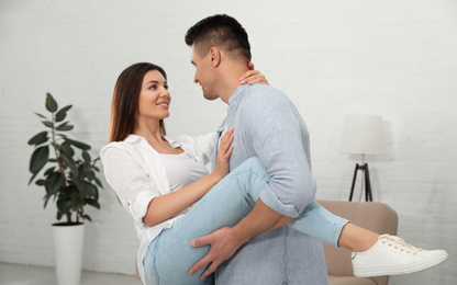 Happy couple dancing in living room at home