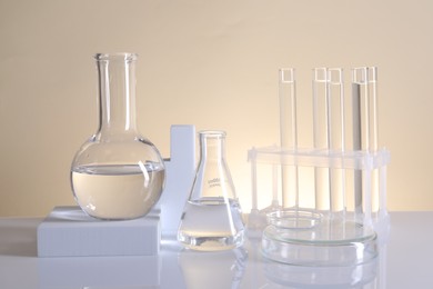 Photo of Laboratory analysis. Different glassware on table against beige background