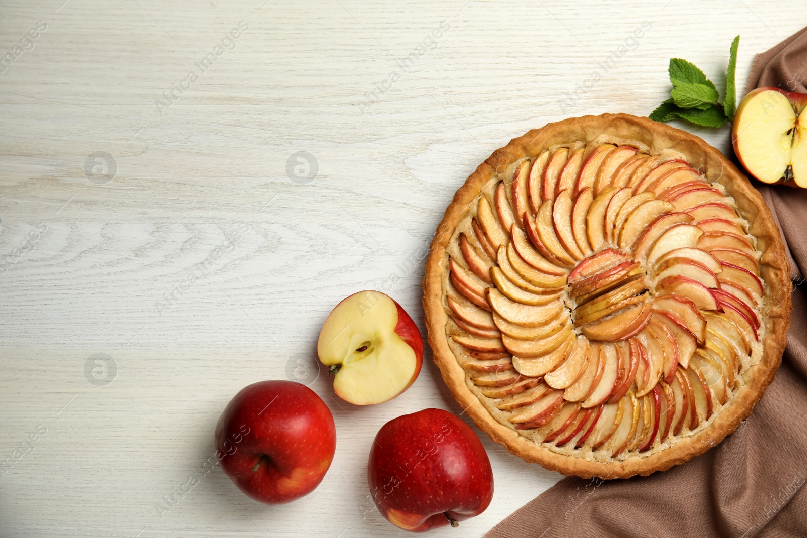 Photo of Delicious homemade apple tart and fresh fruits on white wooden table, flat lay. Space for text