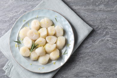 Raw scallops with lemon zest and rosemary on grey marble table, top view. Space for text