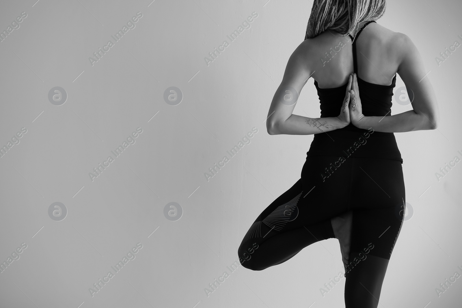 Photo of Young woman practicing yoga on light background