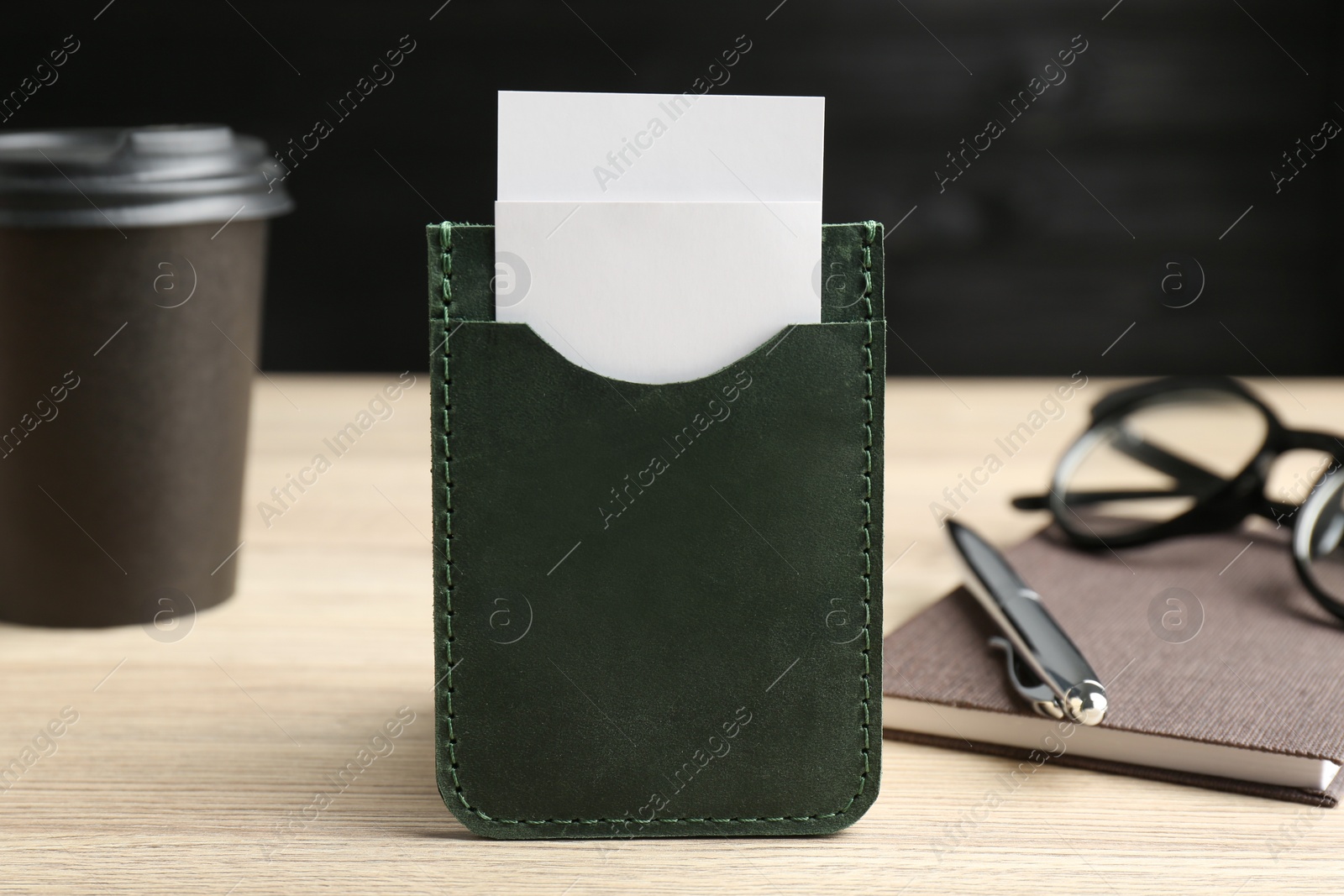 Photo of Leather business card holder with cards on wooden table