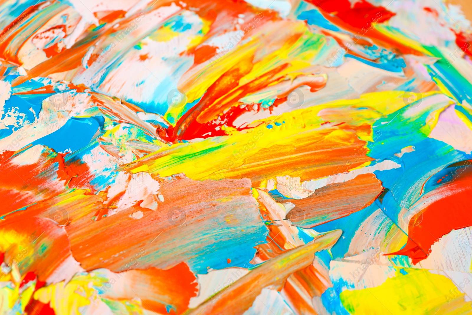 Photo of Closeup view of artist's palette with mixed bright paints as background