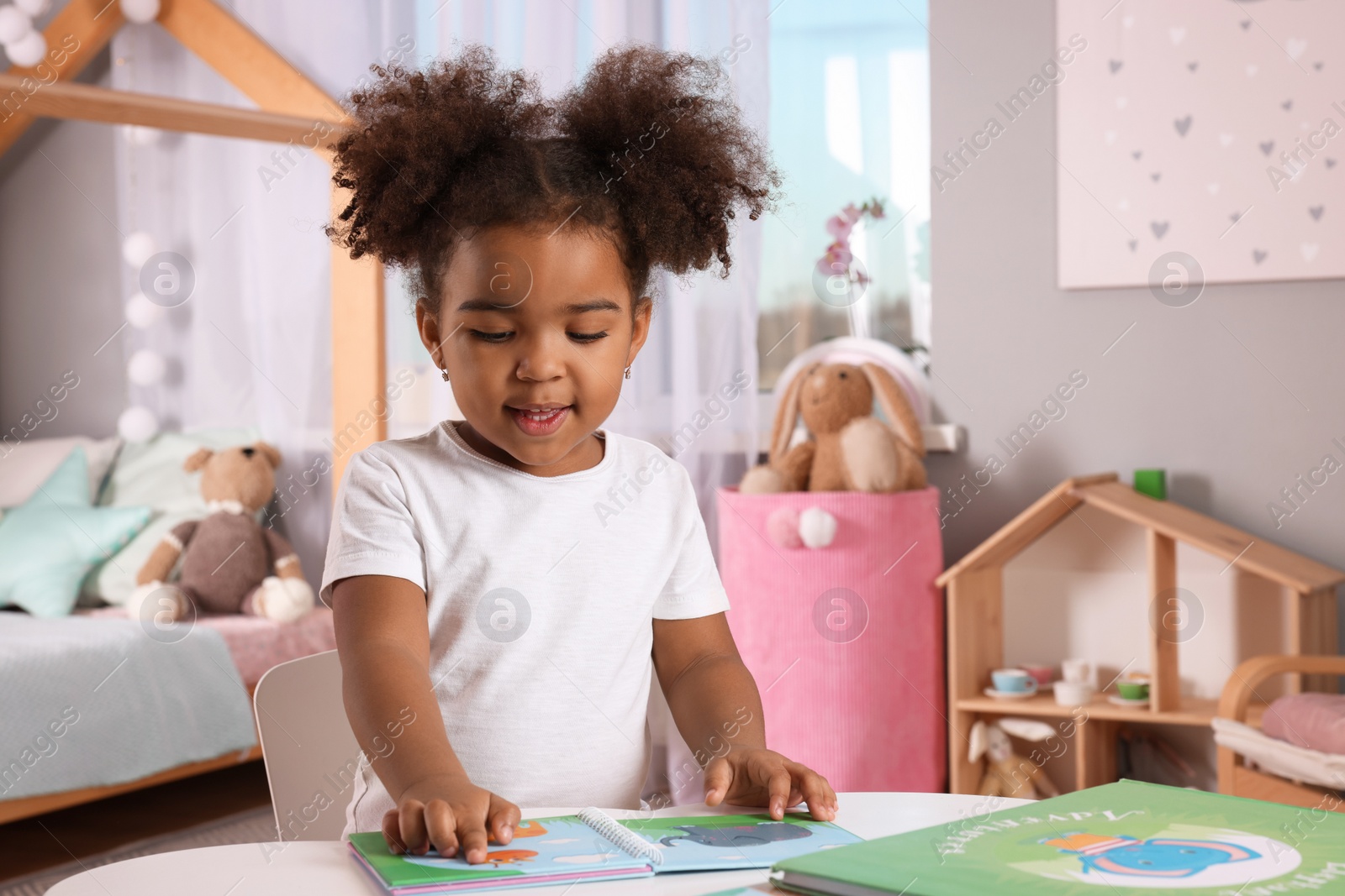 Photo of African American girl reading book at home