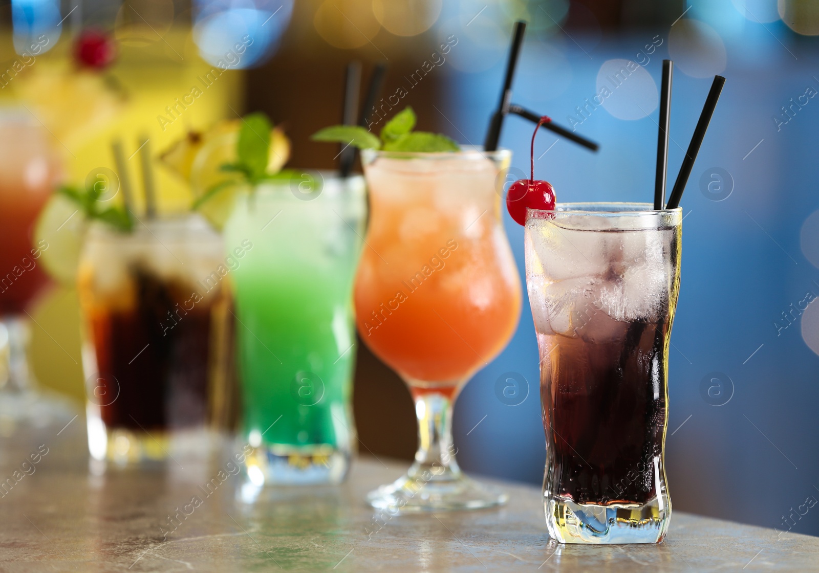 Photo of Row of different fresh alcoholic cocktails on bar counter