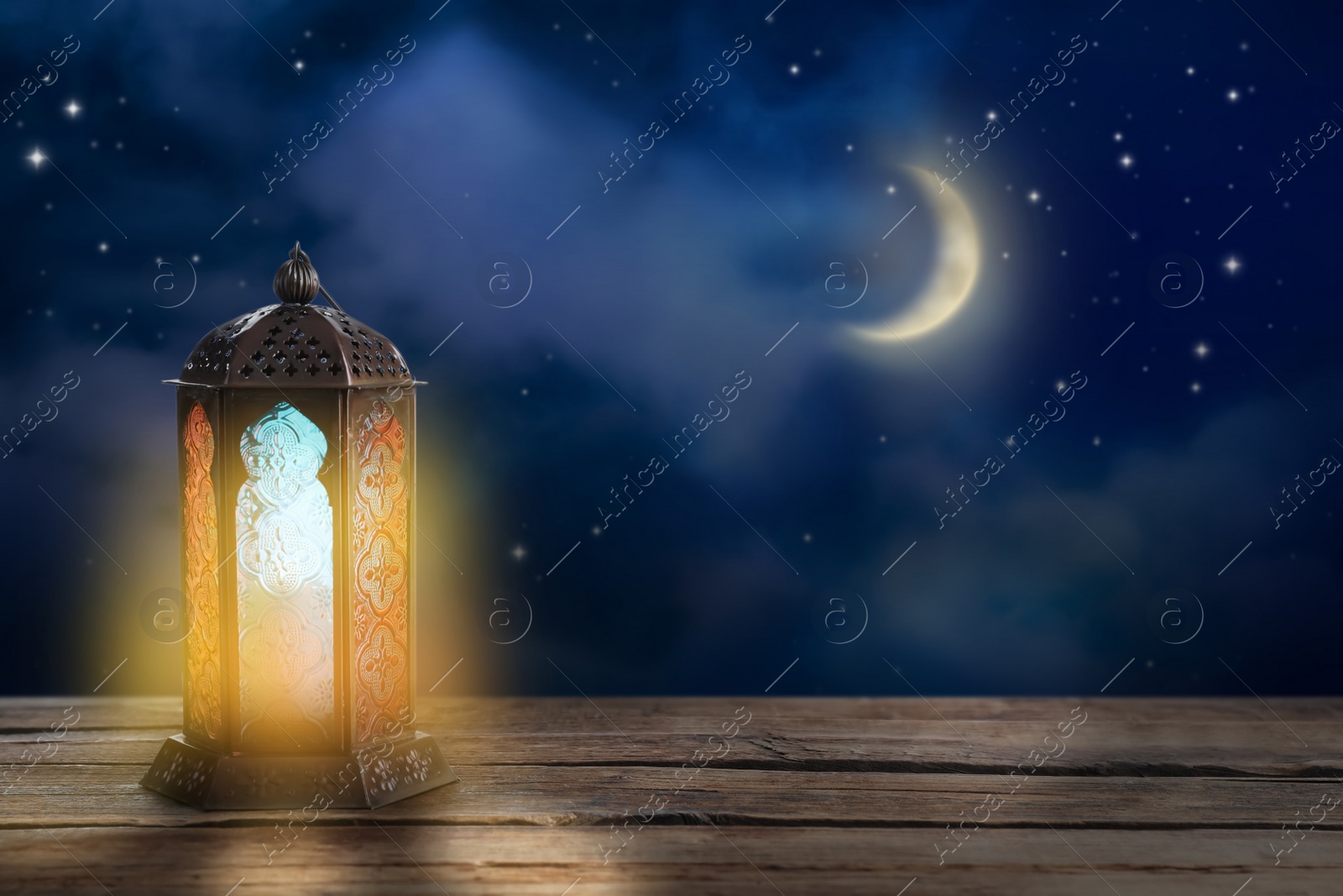 Image of Beautiful decorative Arabic lantern on wooden table at night, space for text. Fanous as Ramadan symbol