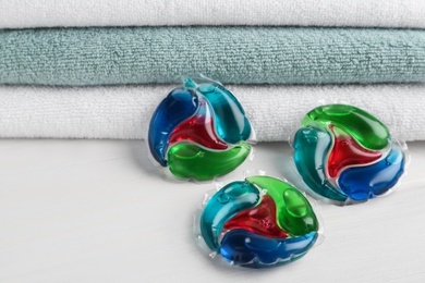 Laundry capsules and towels on white table